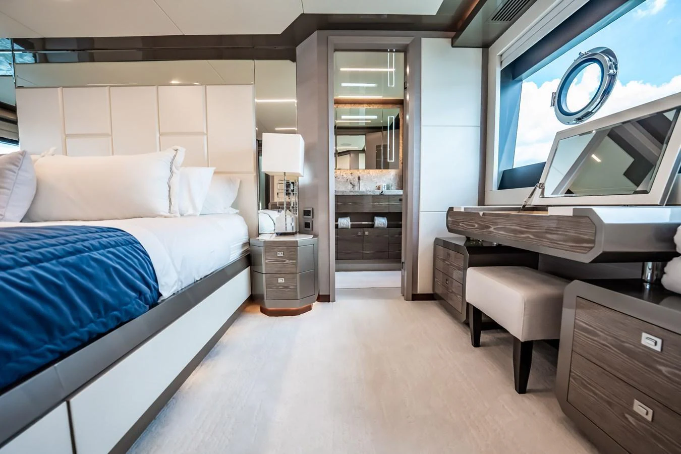 The master stateroom features a luxurious bed, a vanity area, and ample natural light from large windows. aboard AQUASITION Yacht for Sale