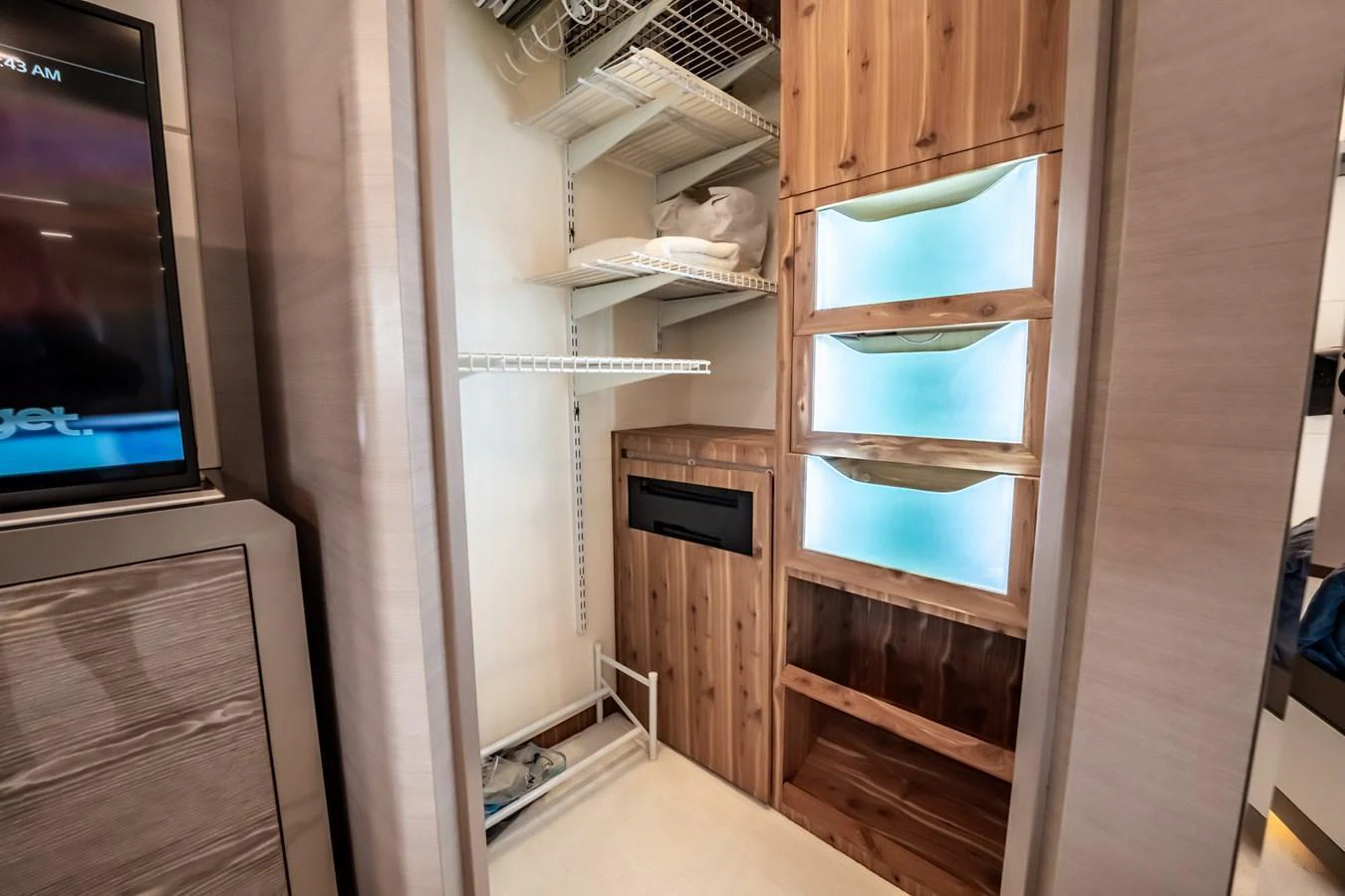 The image showcases a well-organized storage area within the yacht, featuring wooden cabinetry and shelving. aboard AQUASITION Yacht for Sale
