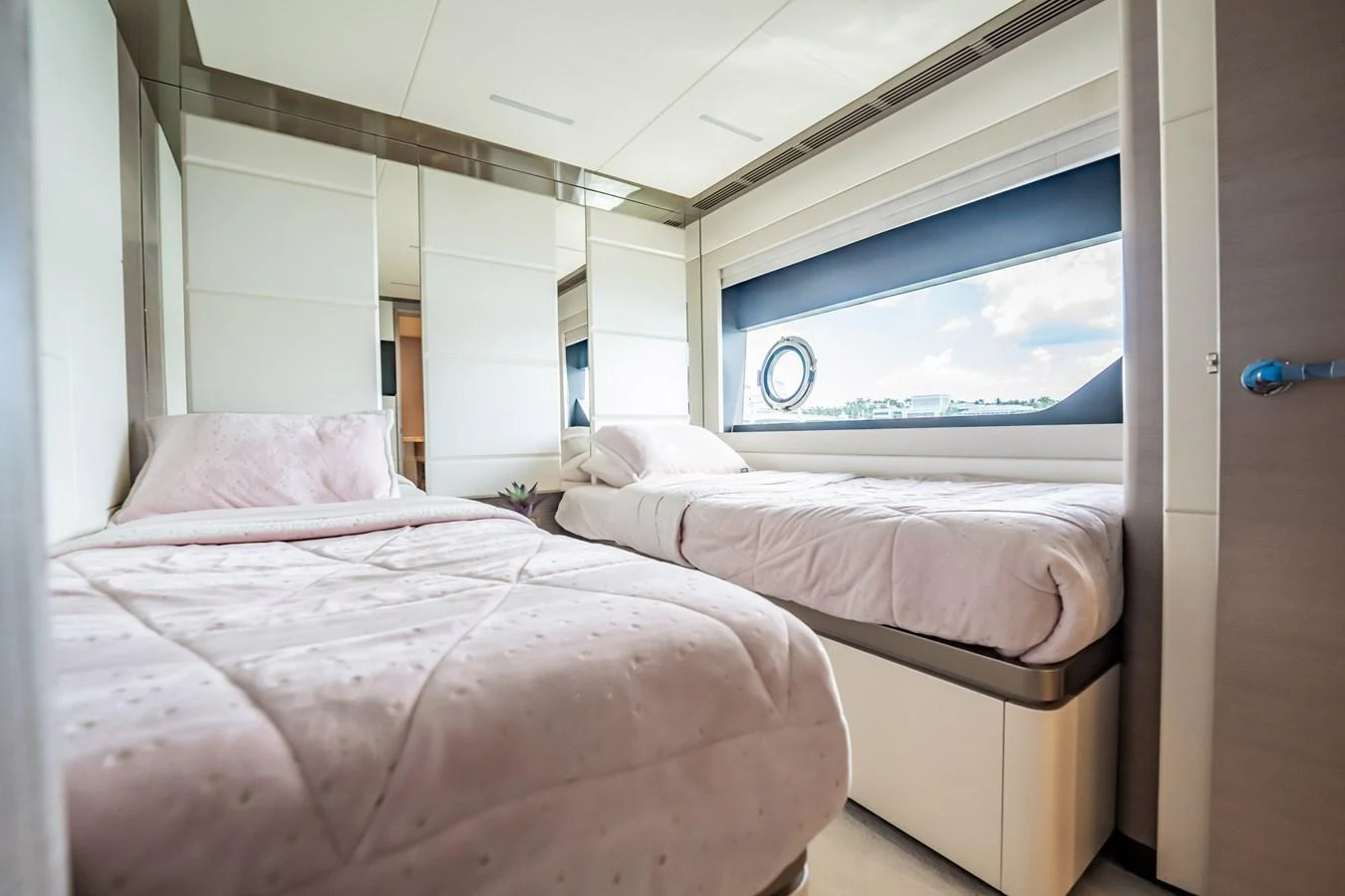 The guest stateroom features two single beds with a large window providing natural light and a view of the sea. aboard AQUASITION Yacht for Sale