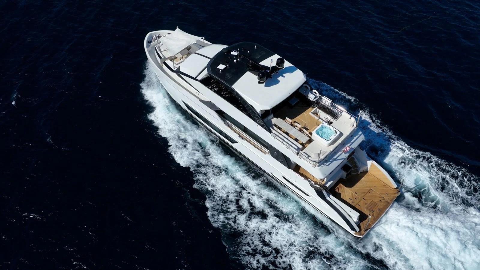 A sleek and modern yacht cruises through deep blue waters, showcasing its luxurious design and spacious deck areas. aboard AQUASITION Yacht for Sale