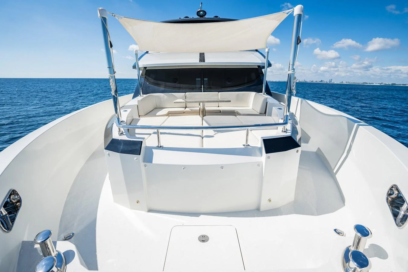 The yacht's bow area features a spacious seating arrangement under a sunshade, perfect for relaxing and enjoying the ocean views. aboard AQUASITION Yacht for Sale