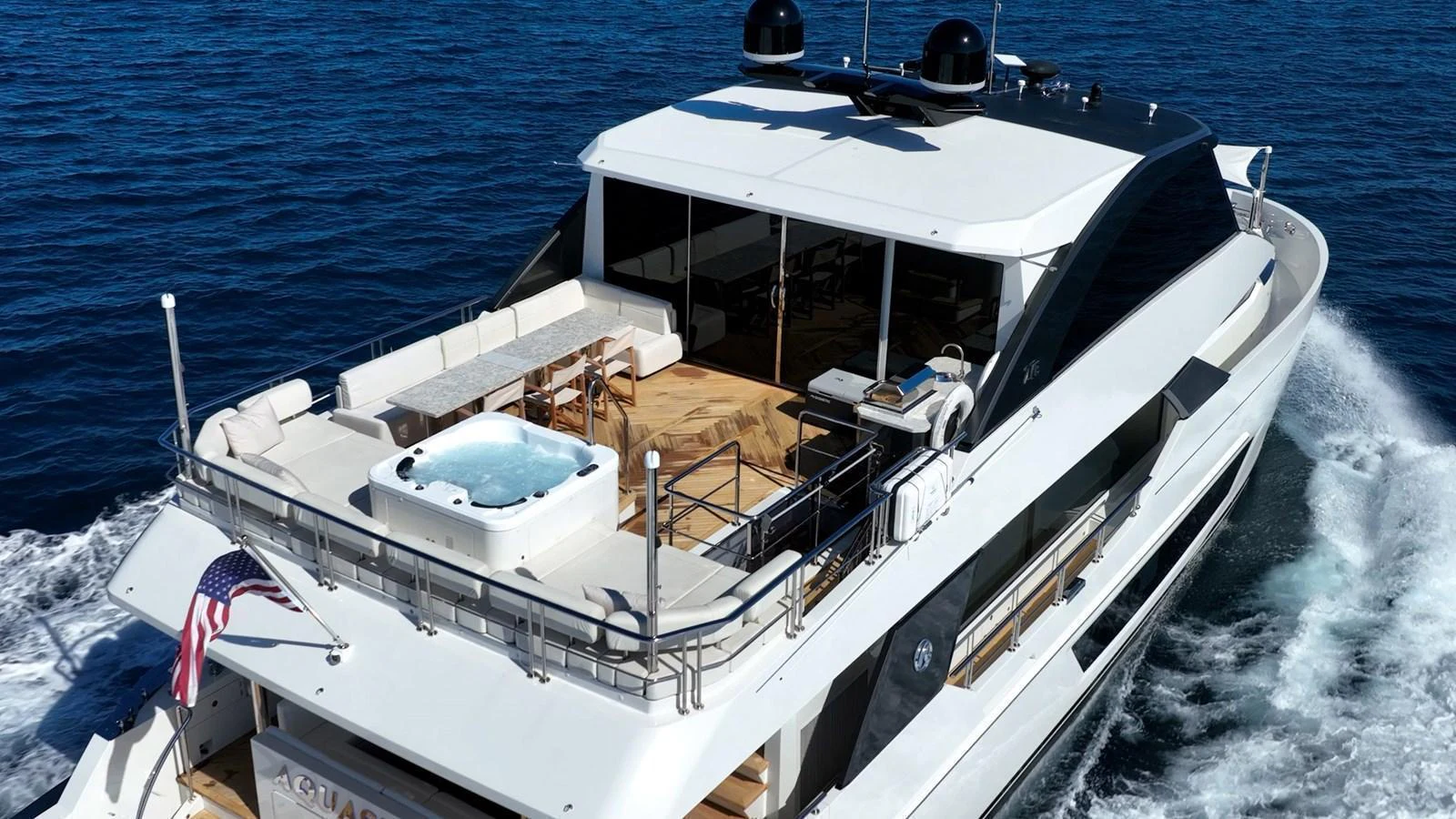 The yacht's aft deck features a spacious lounging area with a hot tub, perfect for relaxation while cruising. aboard AQUASITION Yacht for Sale