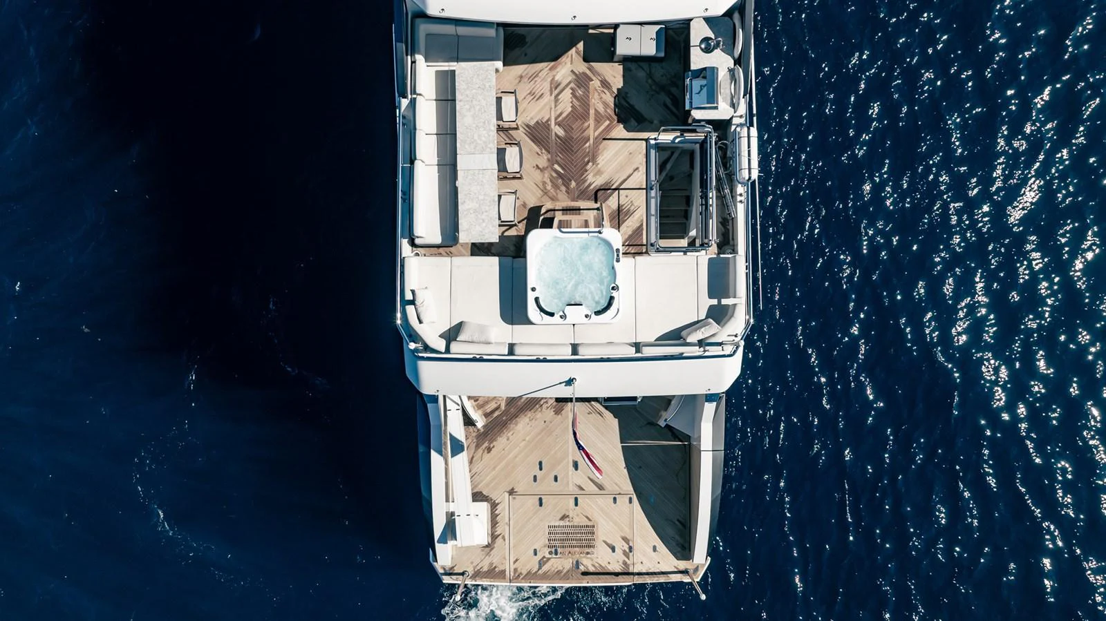 An aerial view of the yacht's aft deck featuring a jacuzzi and spacious lounging area. aboard AQUASITION Yacht for Sale