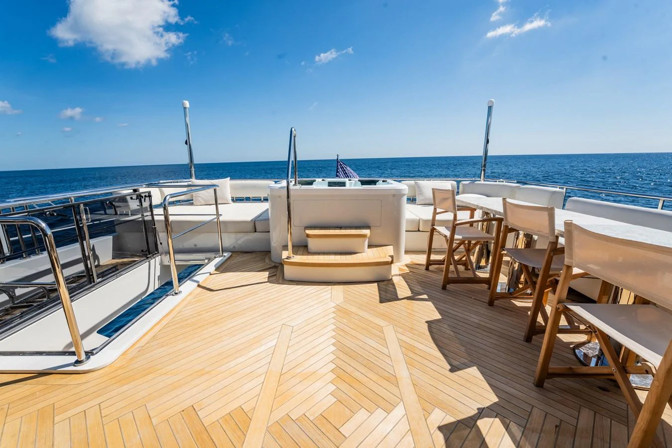 The aft deck features a spacious seating area with a dining table, perfect for enjoying meals with a view of the open sea. aboard AQUASITION Yacht for Sale