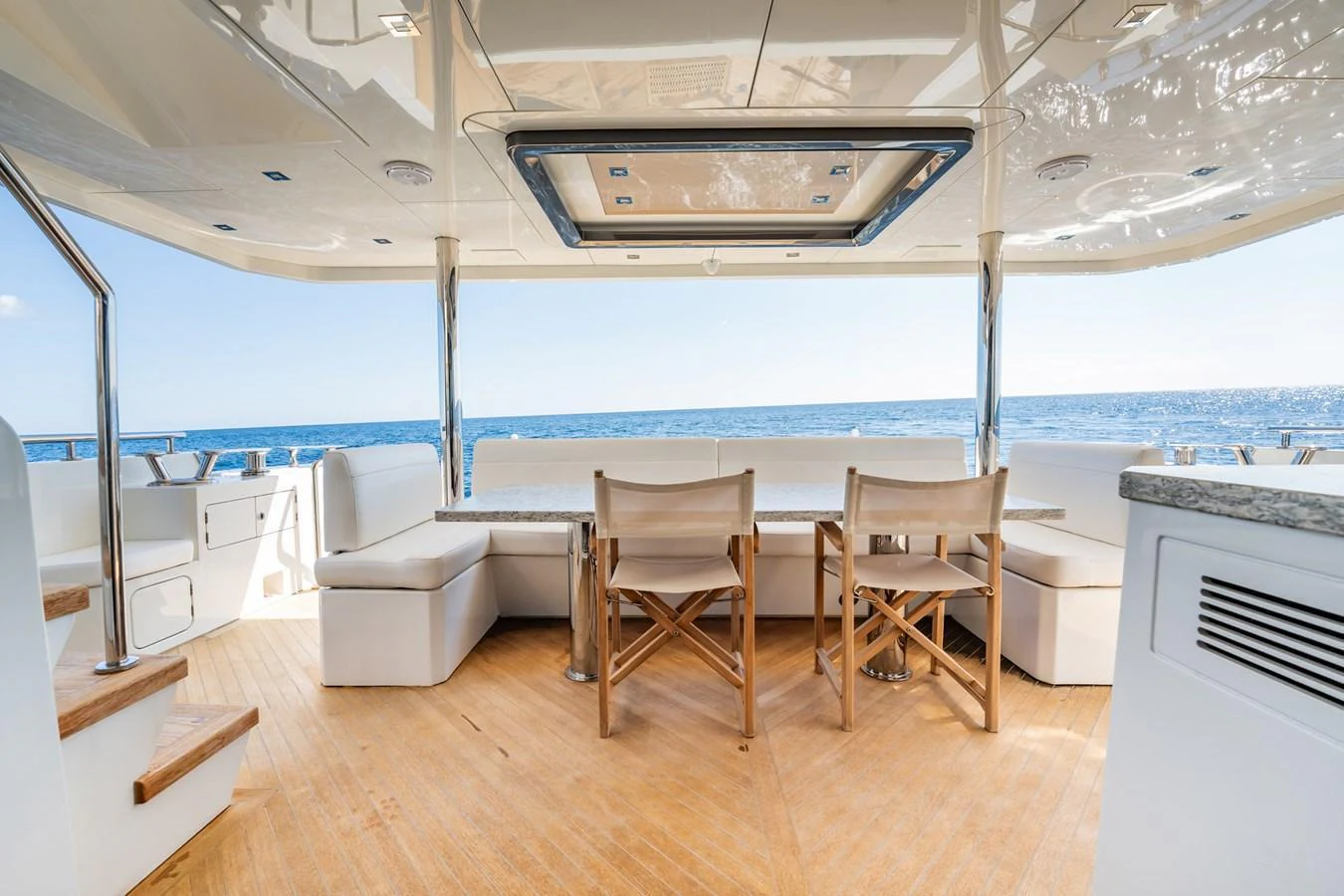 The aft deck features a stylish dining area with comfortable seating and a stunning ocean view. aboard AQUASITION Yacht for Sale
