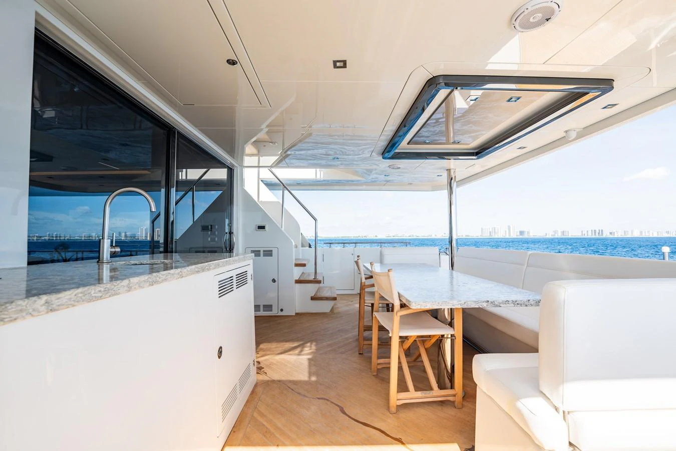 The aft deck features a spacious seating area with a dining table, perfect for enjoying meals with a view of the sea. aboard AQUASITION Yacht for Sale