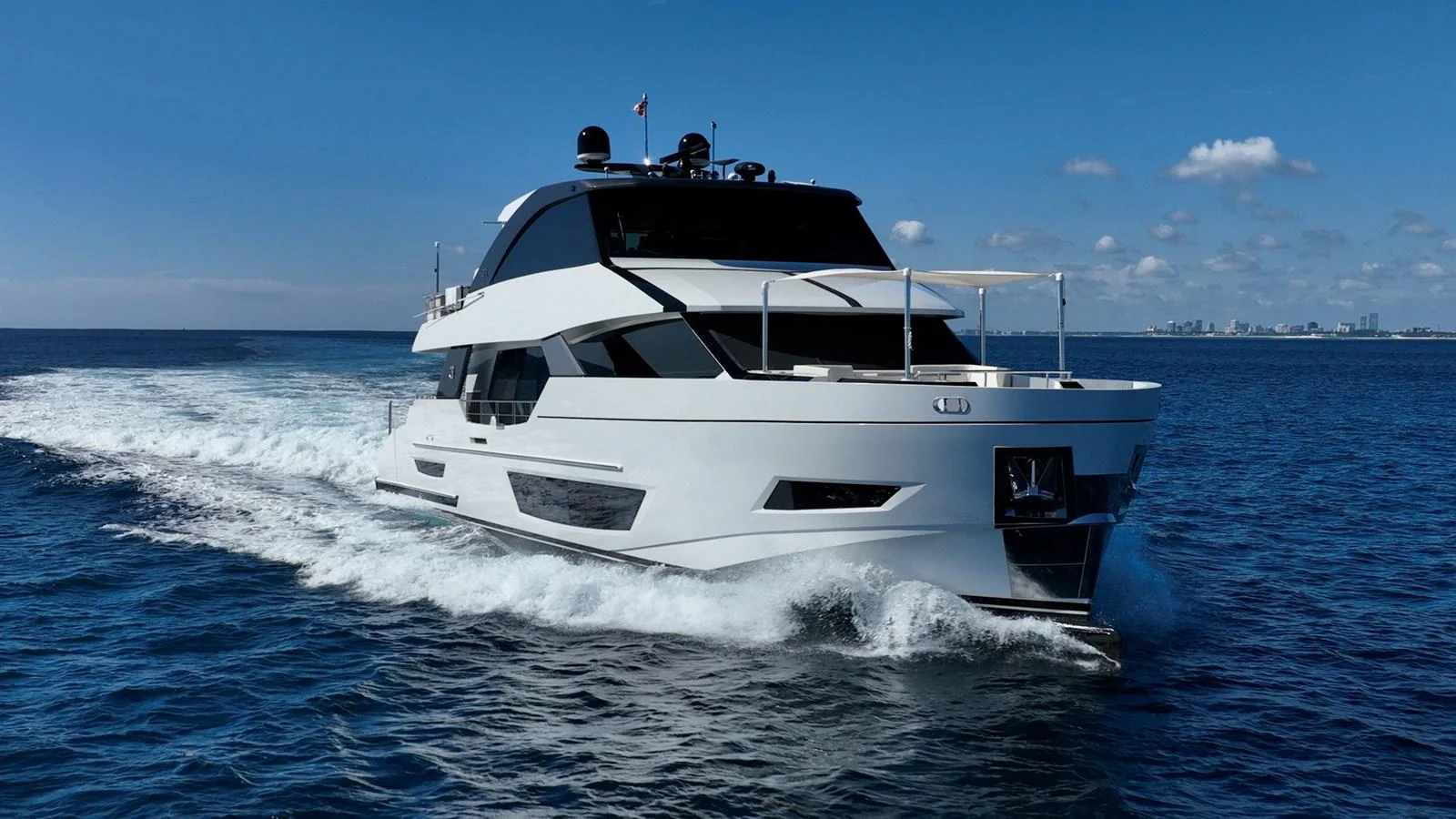 A sleek, modern yacht cruises through calm waters under a clear blue sky. aboard AQUASITION Yacht for Sale