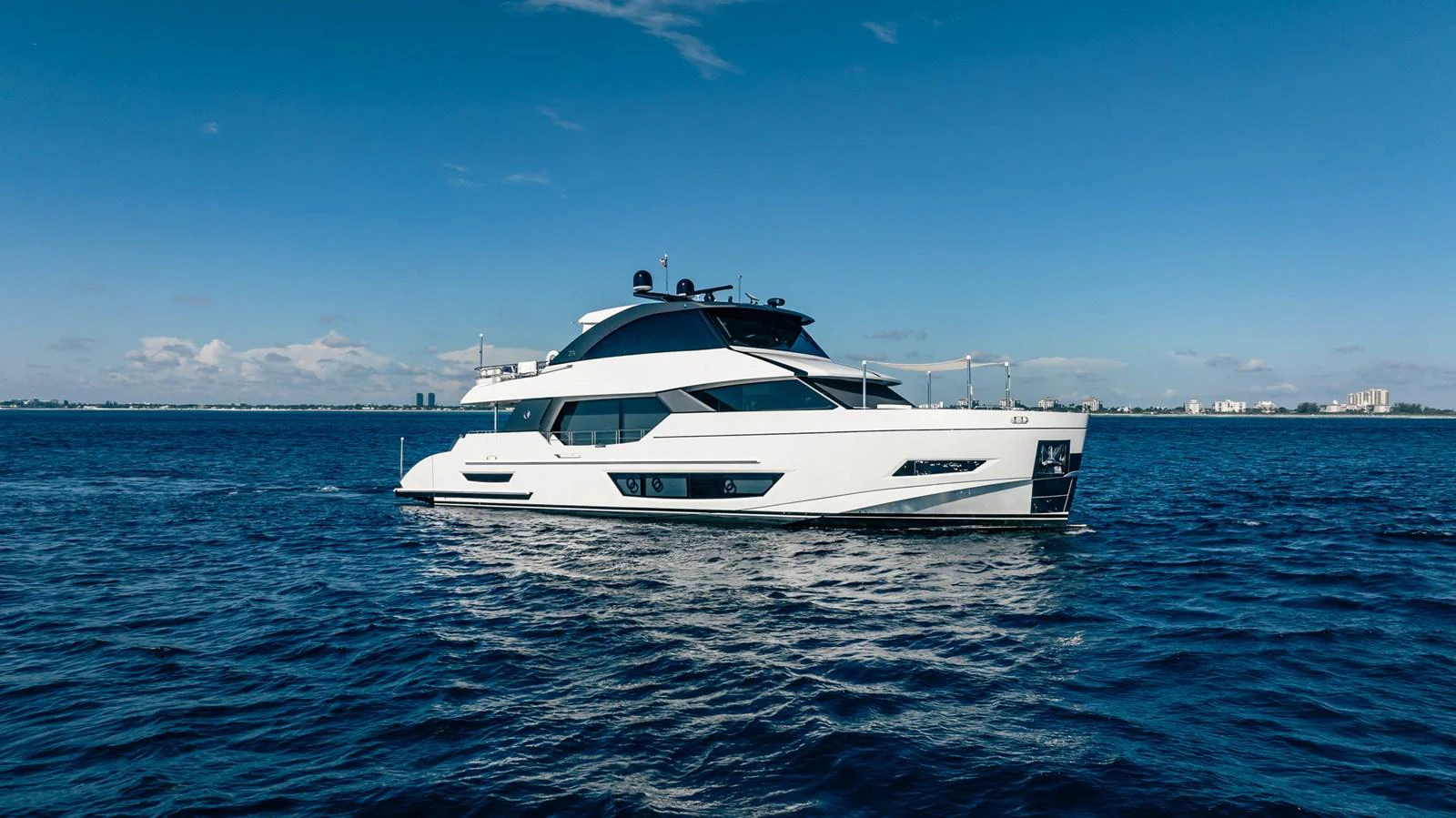 A sleek and modern yacht cruising on calm blue waters under a clear sky. aboard AQUASITION Yacht for Sale