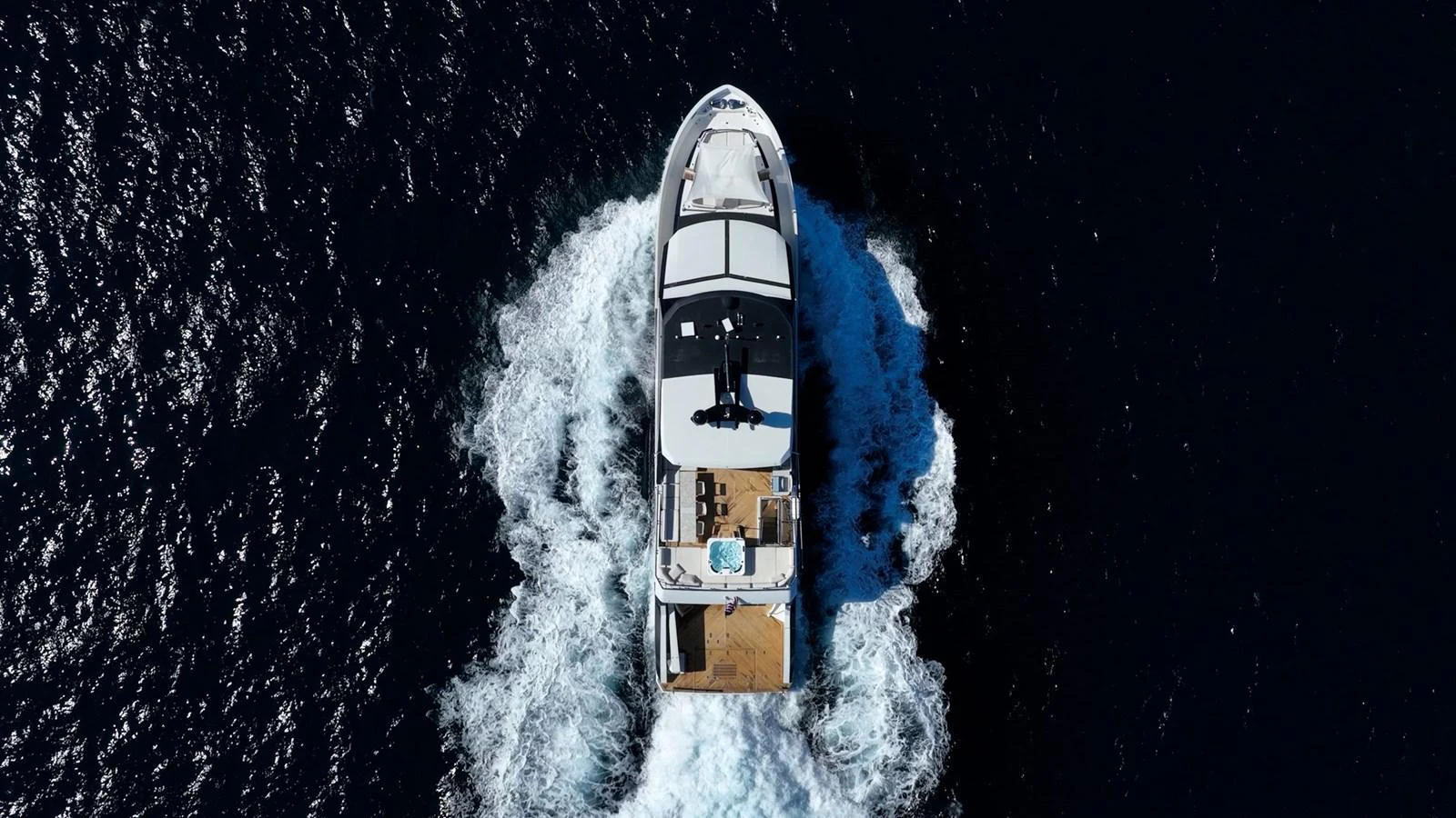 A stunning aerial view of a yacht cruising through the water, showcasing its sleek design and spacious deck. aboard AQUASITION Yacht for Sale