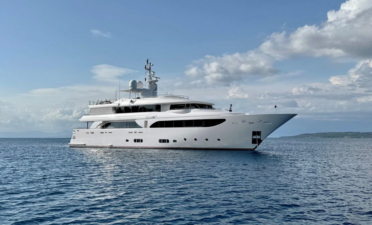 A sleek and modern yacht glides gracefully on calm waters under a partly cloudy sky. aboard EMOTION 2 Yacht for Sale
