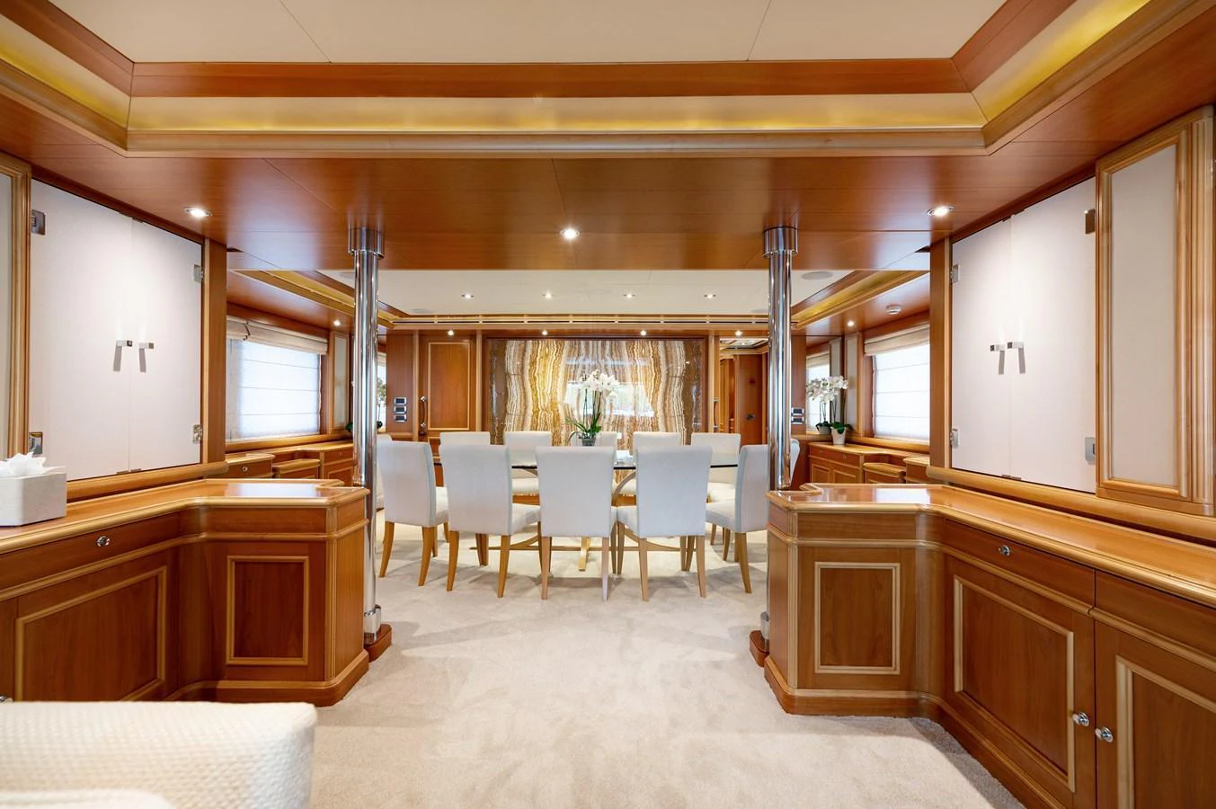 The yacht's dining area features elegant wooden finishes and a spacious, well-lit setting. aboard EMOTION 2 Yacht for Sale