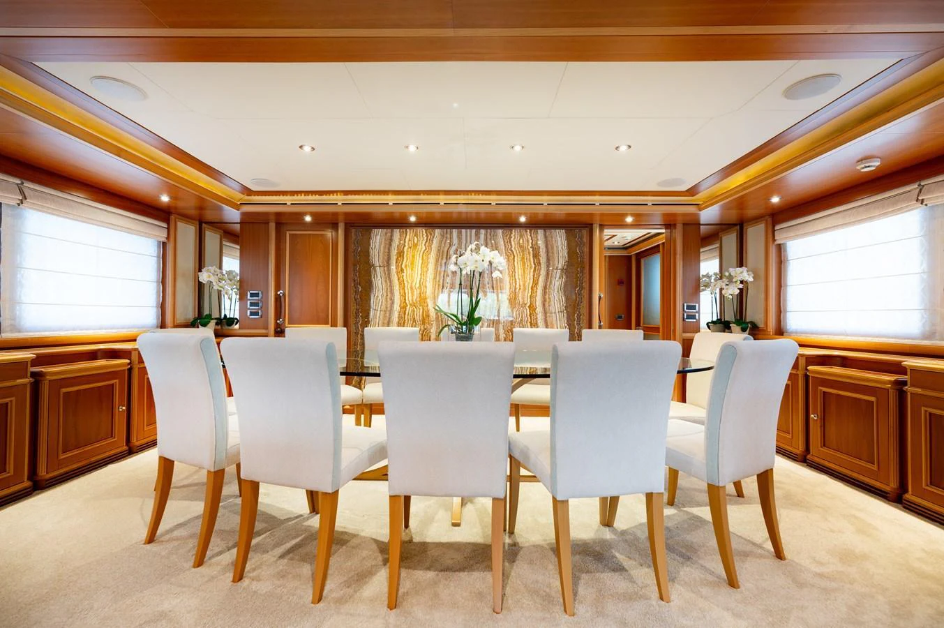 The yacht's dining area features elegant wooden paneling and plush seating, creating a refined and inviting atmosphere. aboard EMOTION 2 Yacht for Sale