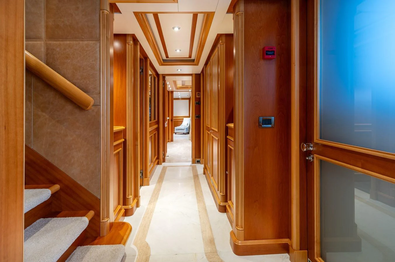 A luxurious hallway with warm wooden paneling and soft lighting. aboard EMOTION 2 Yacht for Sale