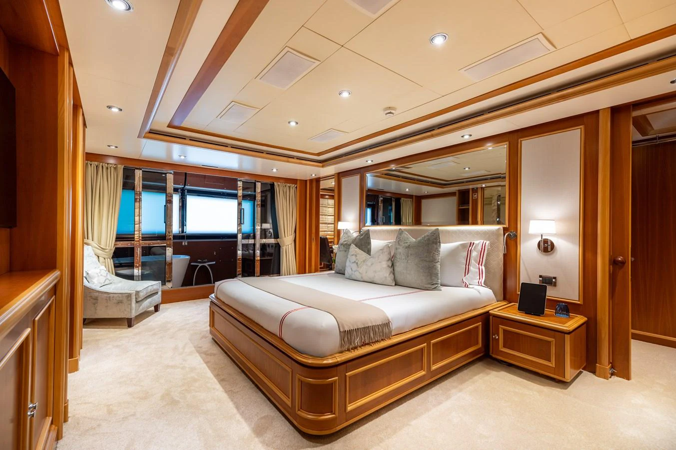 The master stateroom features a luxurious bed with elegant wood paneling and ample natural light. aboard EMOTION 2 Yacht for Sale