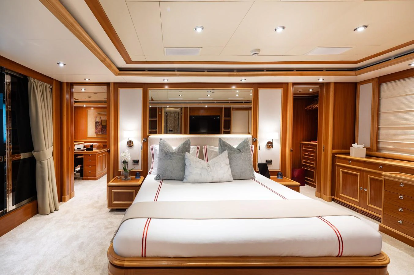 The master stateroom features a luxurious bed with elegant wood paneling and ample lighting. aboard EMOTION 2 Yacht for Sale