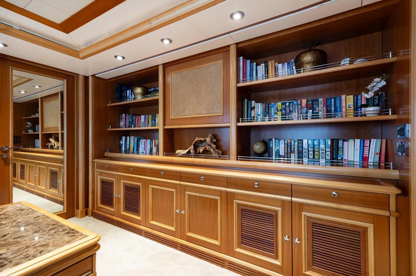 The yacht's interior features a luxurious library with wooden cabinetry and a collection of books. aboard EMOTION 2 Yacht for Sale