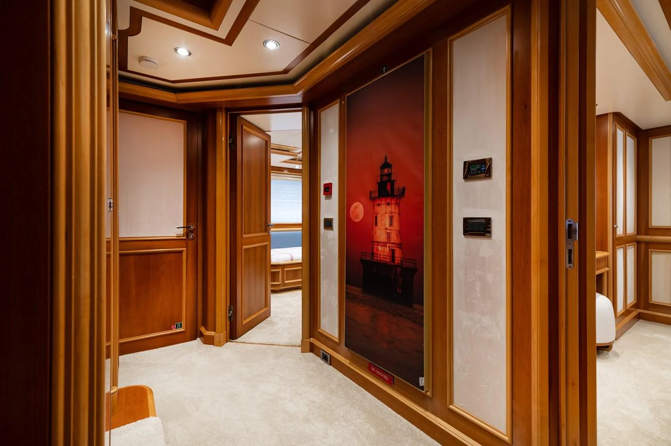 The yacht's interior hallway features warm wood paneling and a lighthouse painting, creating a cozy and inviting atmosphere. aboard EMOTION 2 Yacht for Sale