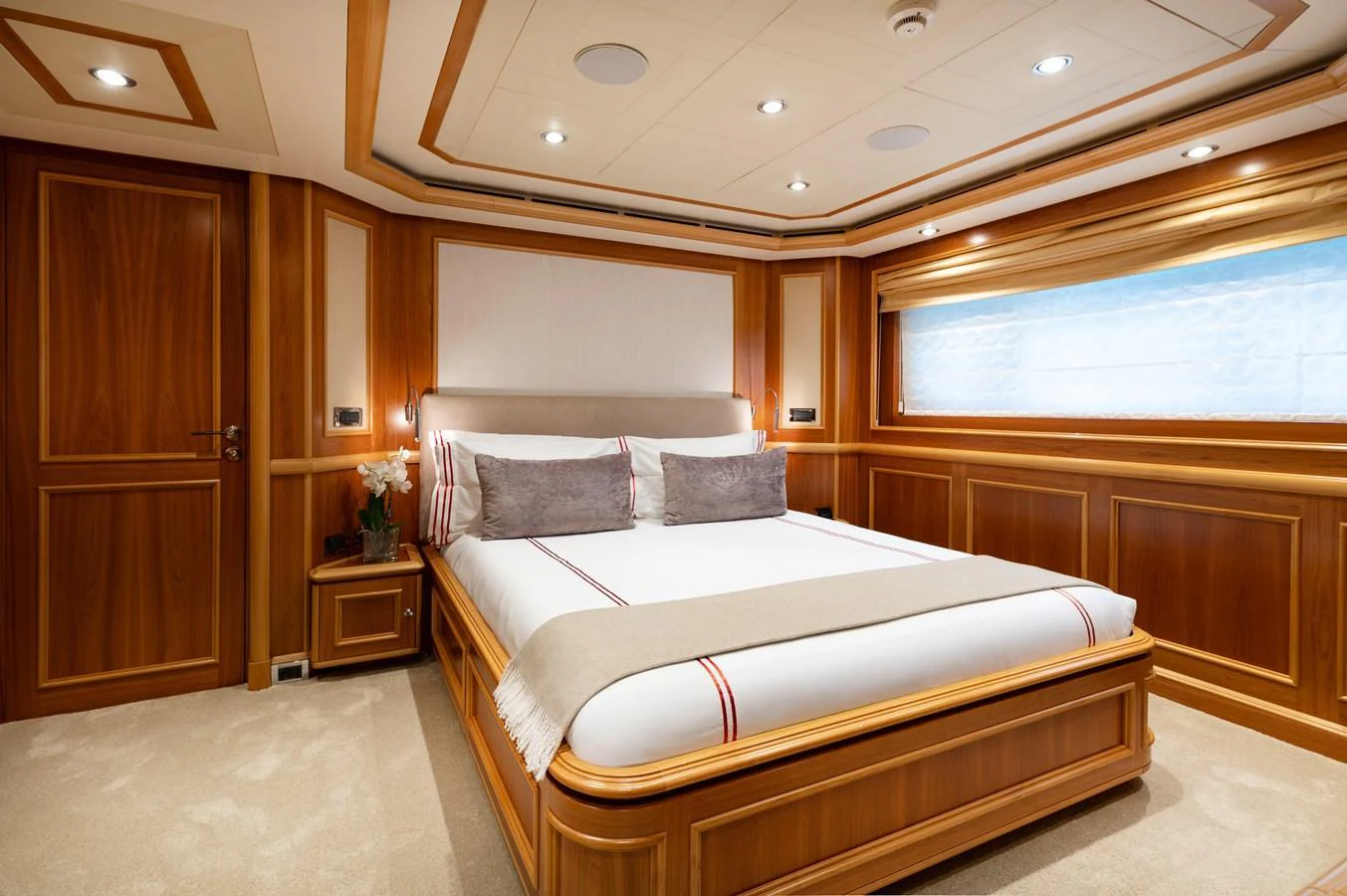 A luxurious stateroom featuring a large bed with elegant wooden paneling and soft lighting. aboard EMOTION 2 Yacht for Sale
