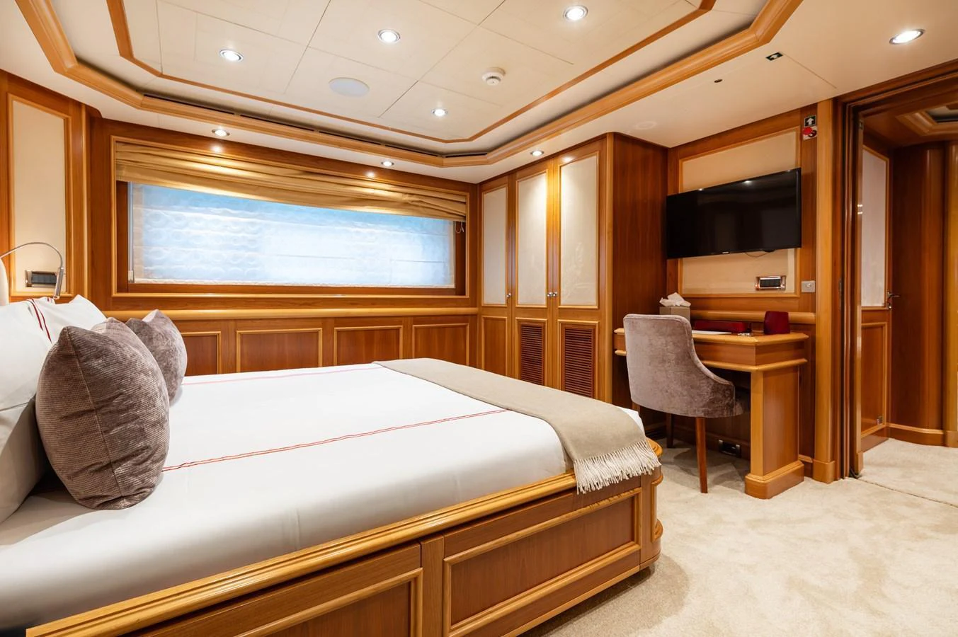 The stateroom features luxurious wood paneling, a comfortable bed, and a cozy workspace. aboard EMOTION 2 Yacht for Sale