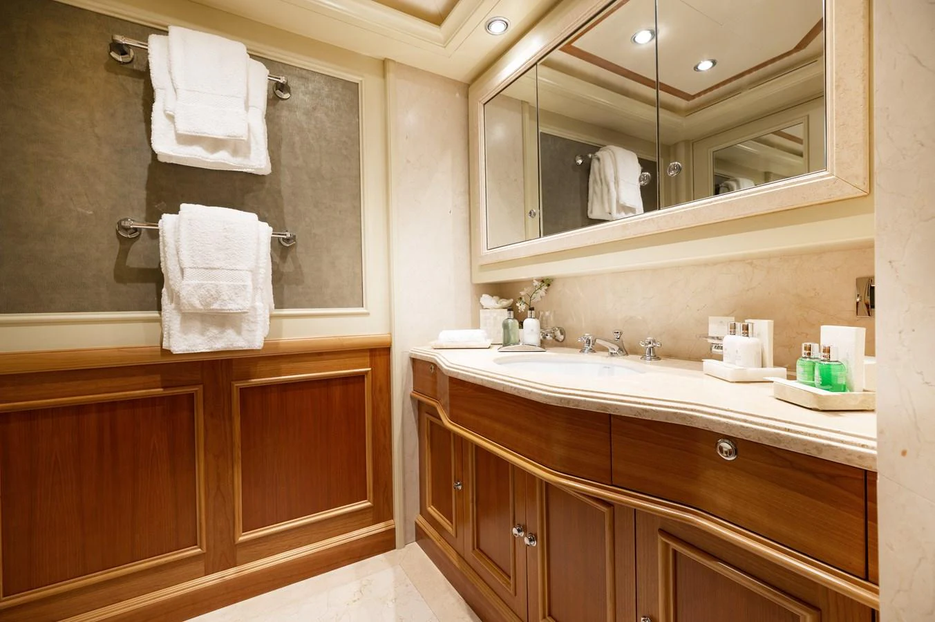 The yacht's bathroom features elegant wood paneling and a spacious vanity area with luxurious amenities. aboard EMOTION 2 Yacht for Sale