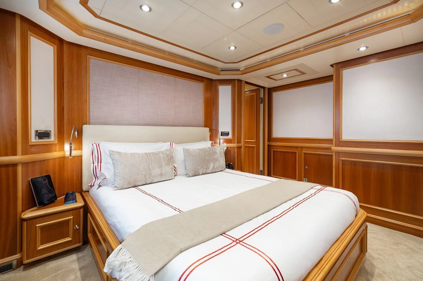 The master stateroom features a luxurious bed with elegant wood paneling and soft lighting. aboard EMOTION 2 Yacht for Sale