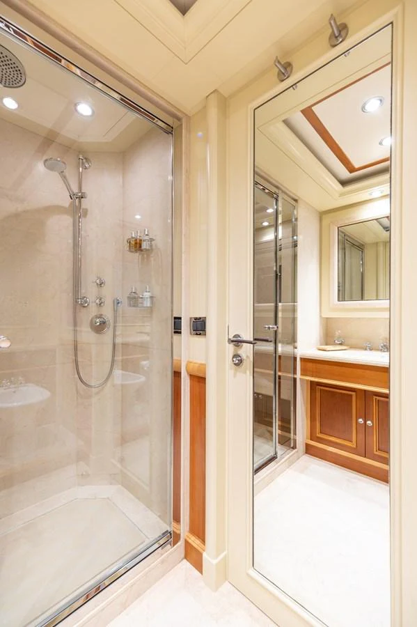 The yacht's bathroom features a glass-enclosed shower and a vanity with a large mirror. aboard EMOTION 2 Yacht for Sale