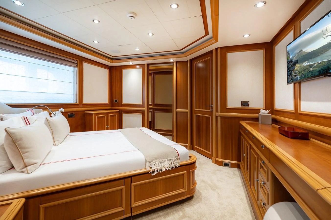 The stateroom features a luxurious bed, ample storage, and elegant wooden finishes. aboard EMOTION 2 Yacht for Sale