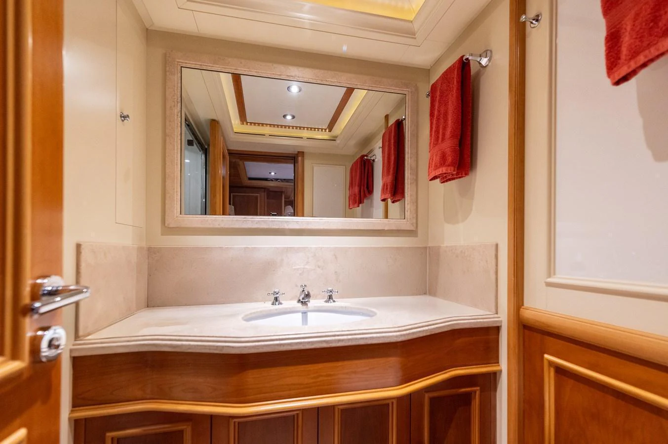The yacht's bathroom features elegant wood paneling and a large mirror above the sink. aboard EMOTION 2 Yacht for Sale