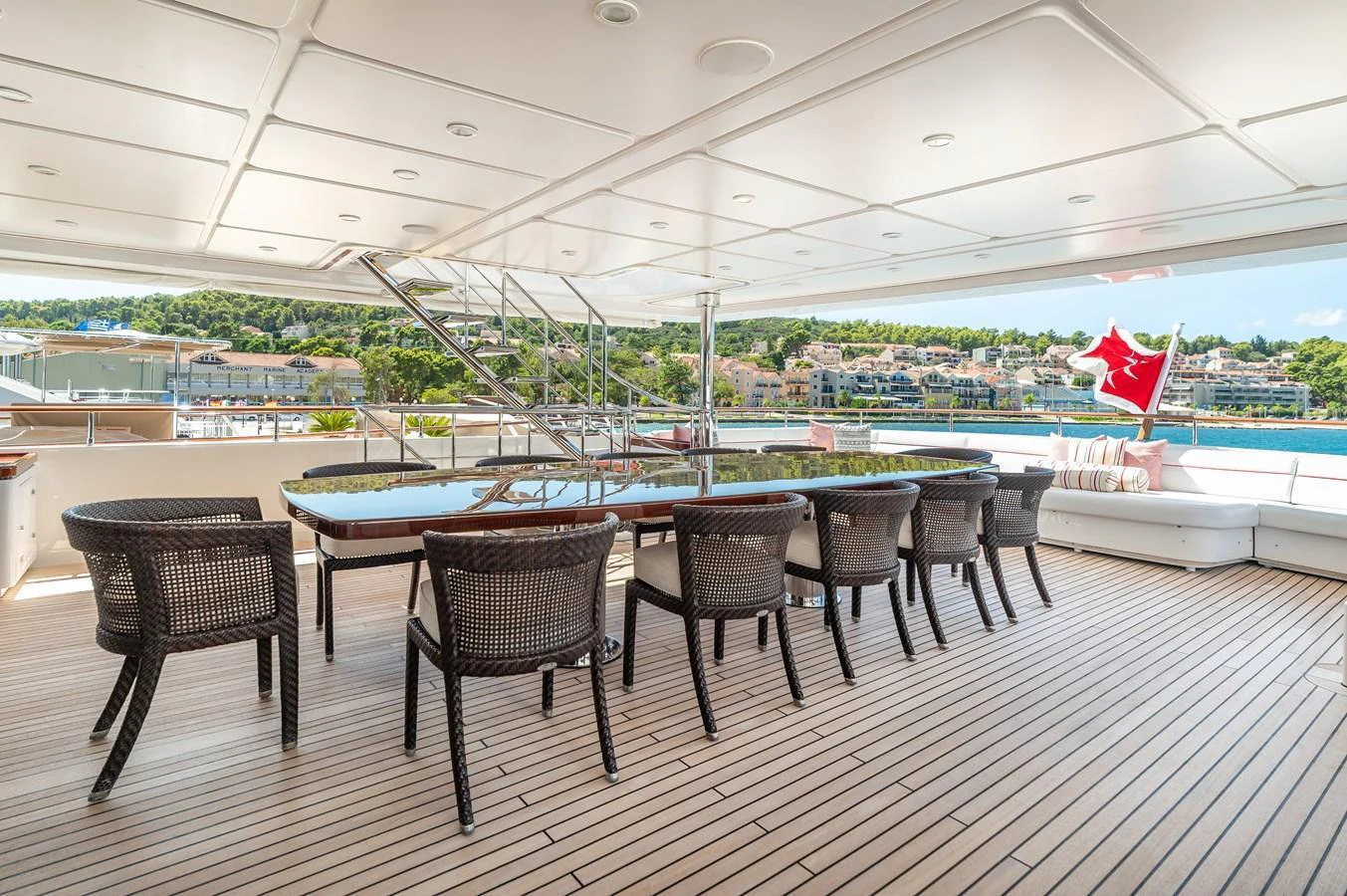 The aft deck features a spacious dining area with a large table and comfortable seating, perfect for alfresco meals with a view. aboard EMOTION 2 Yacht for Sale