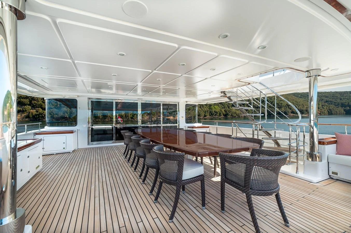The aft deck features a spacious dining area with elegant seating and a beautiful view. aboard EMOTION 2 Yacht for Sale