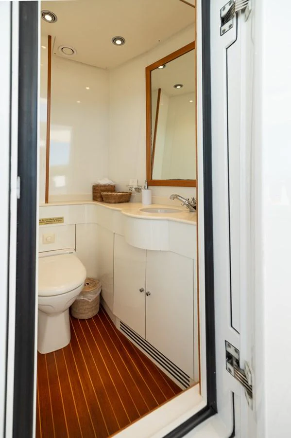 The yacht's head features a sleek design with modern fixtures and wooden flooring. aboard EMOTION 2 Yacht for Sale