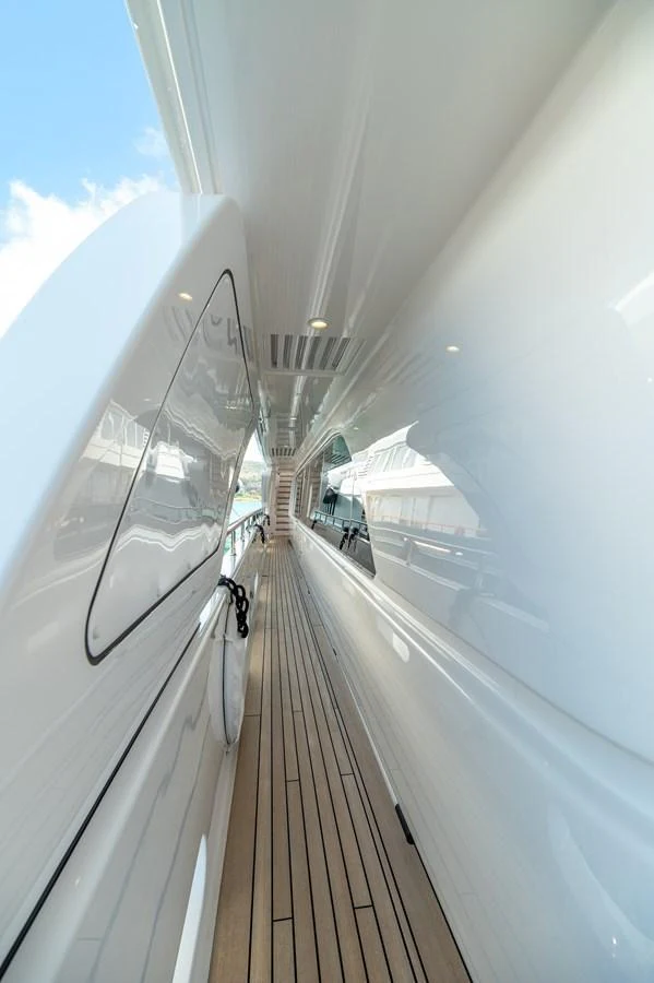 A sleek and polished side deck with teak flooring and modern lighting. aboard EMOTION 2 Yacht for Sale