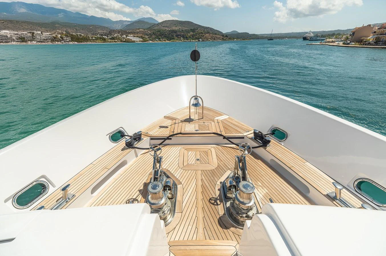 The foredeck offers a spacious and pristine area with polished wood and stainless steel fittings, perfect for enjoying the view. aboard EMOTION 2 Yacht for Sale