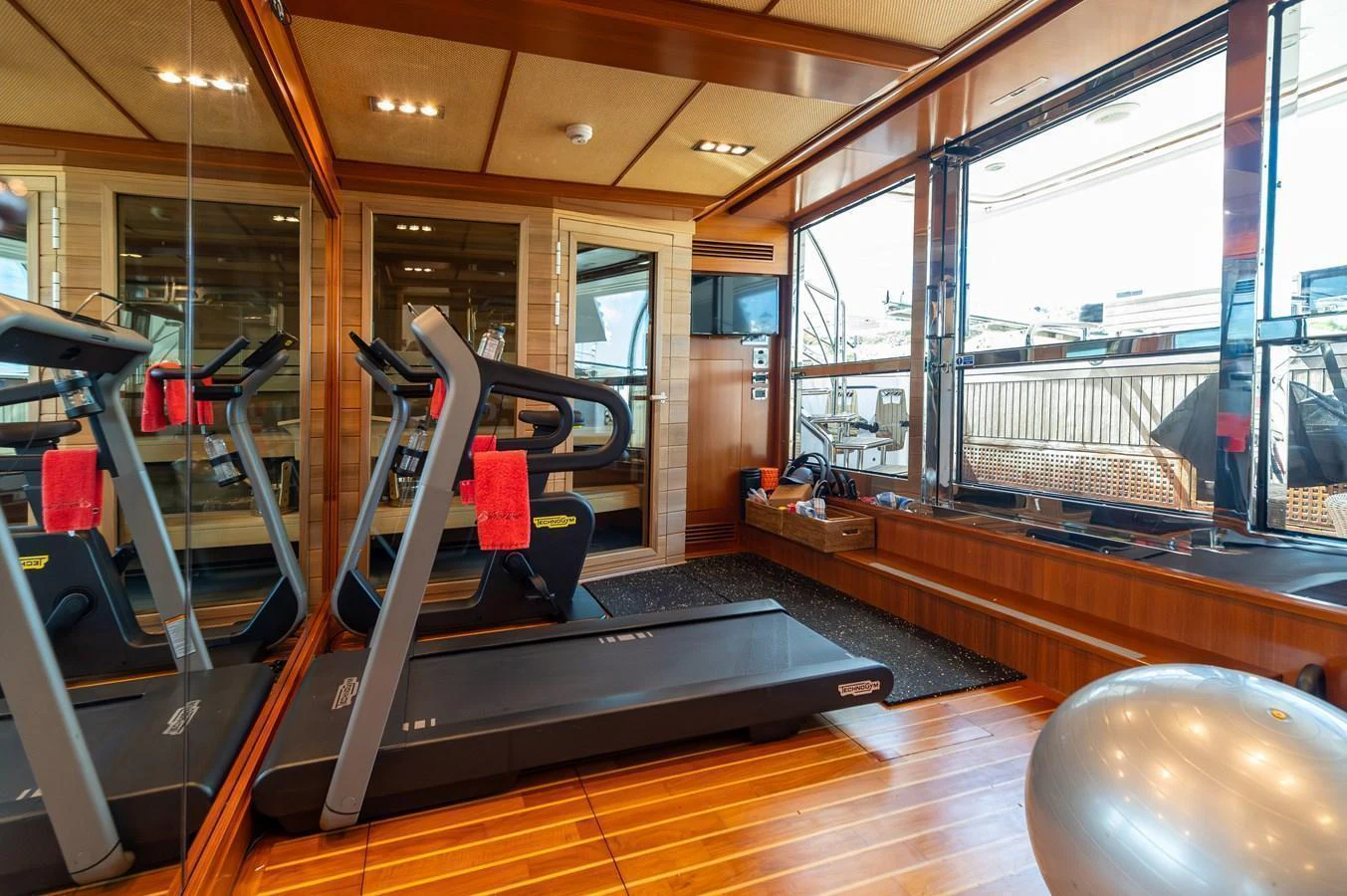 The yacht's gym is equipped with modern fitness equipment and offers a bright, spacious environment for workouts. aboard EMOTION 2 Yacht for Sale