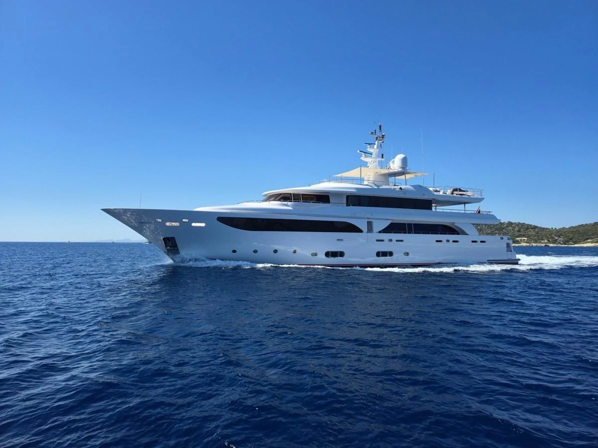 A sleek and elegant yacht glides through the open sea under a clear blue sky. aboard EMOTION 2 Yacht for Sale