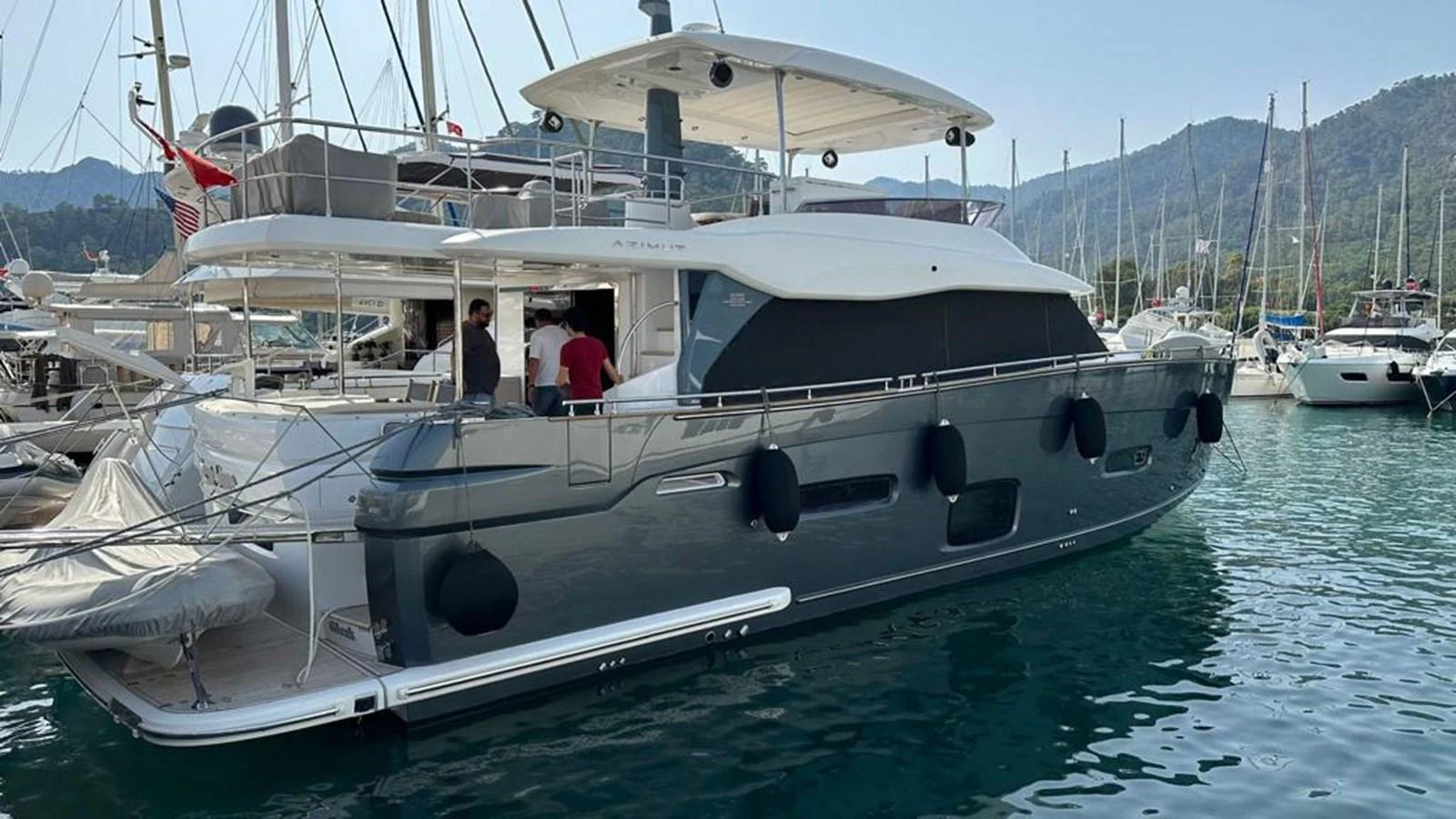 This sleek yacht is docked in a serene marina, showcasing its modern design and elegant lines. aboard NINE NINE WINE Yacht for Sale