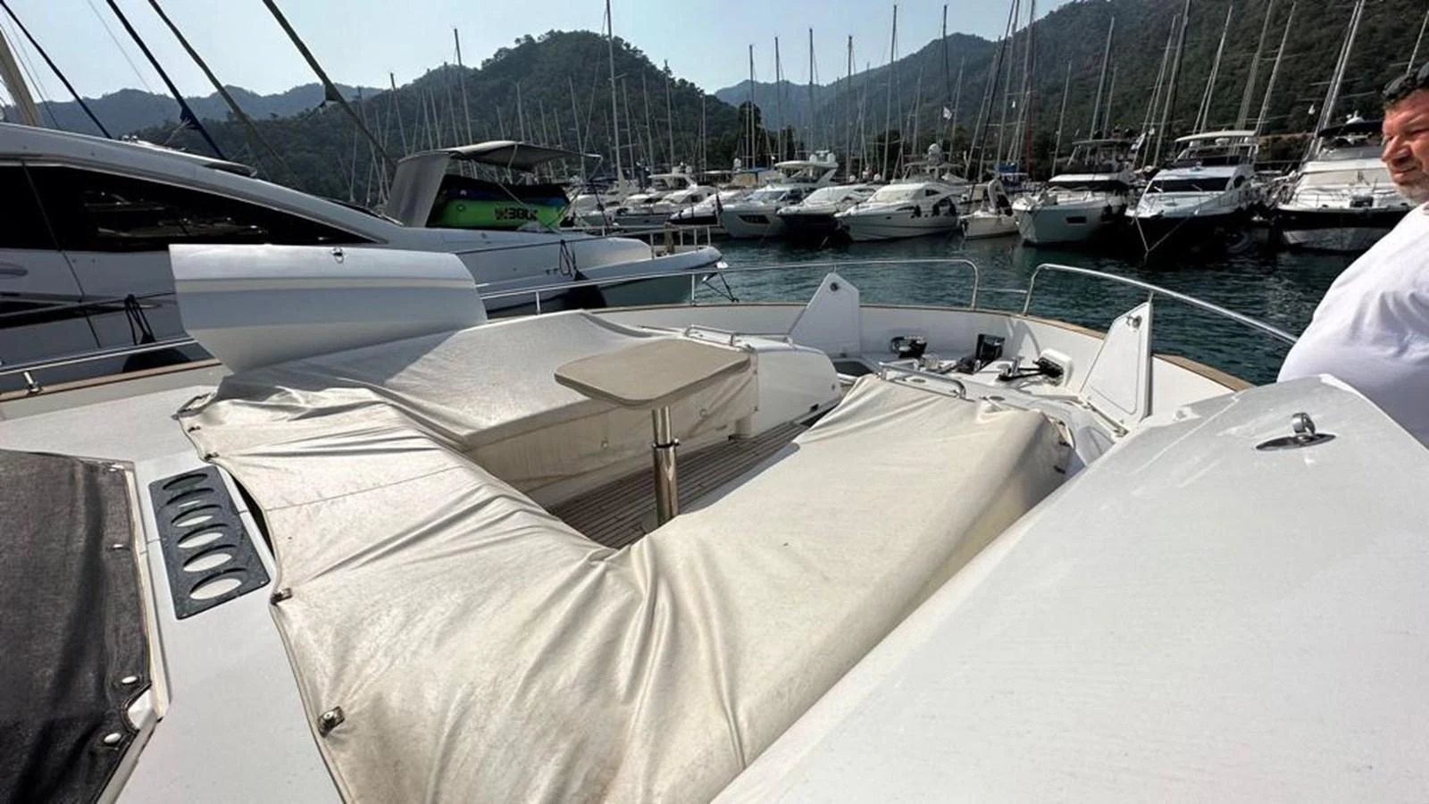 The yacht's foredeck features a spacious sunbathing area with a retractable cover and a small table, perfect for relaxation. aboard NINE NINE WINE Yacht for Sale