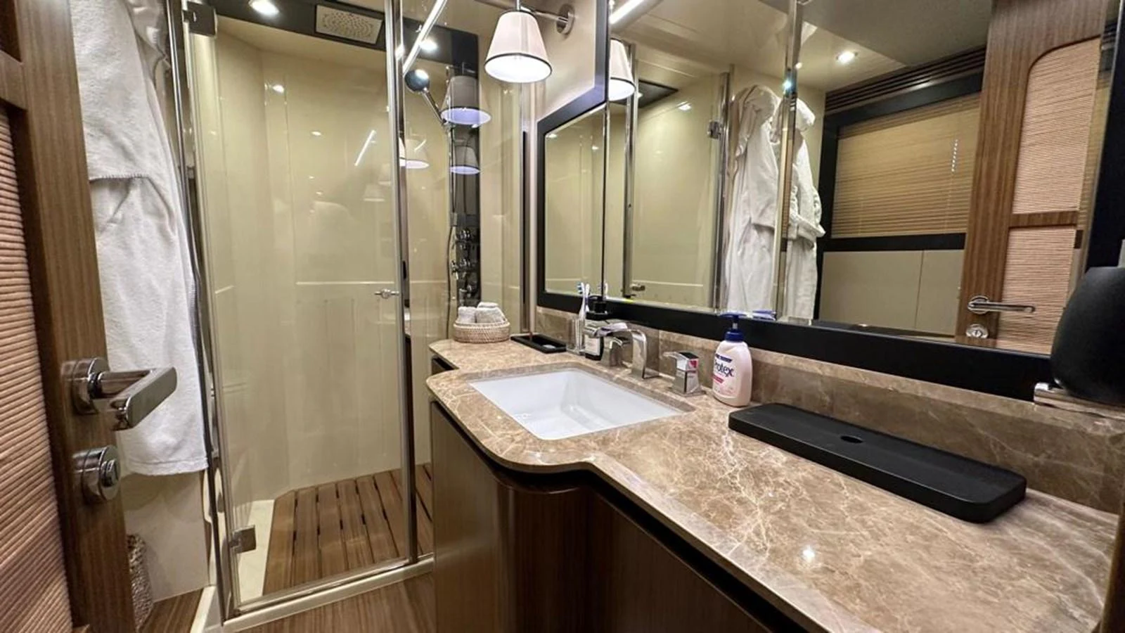 The yacht's bathroom features a luxurious marble countertop and a spacious glass-enclosed shower. aboard NINE NINE WINE Yacht for Sale