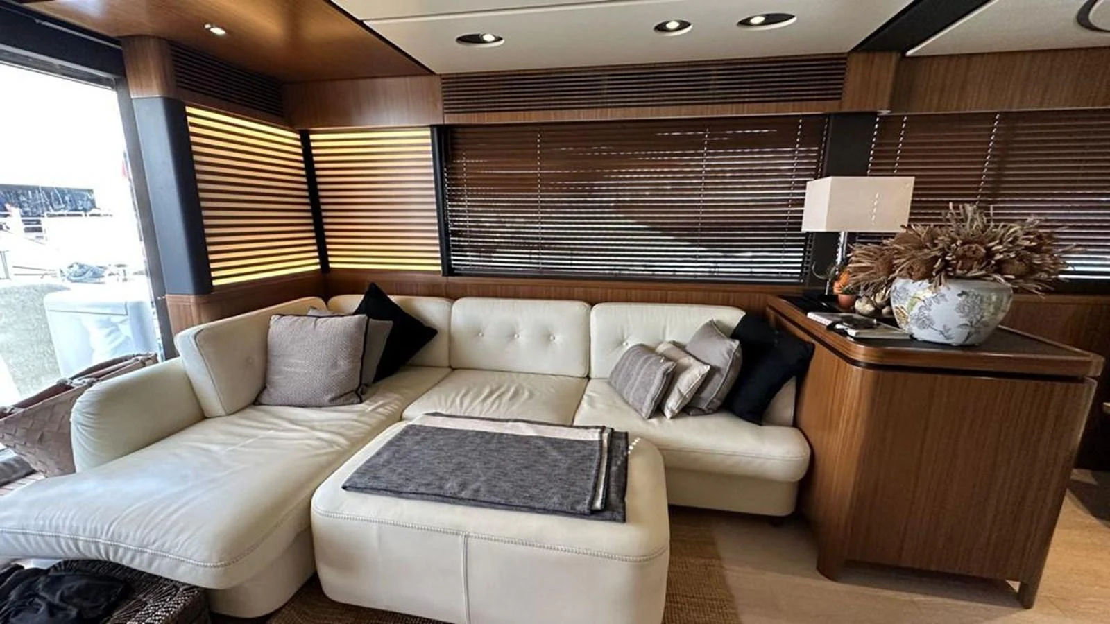 The salon features a plush white sectional sofa with elegant wooden accents and modern lighting. aboard NINE NINE WINE Yacht for Sale