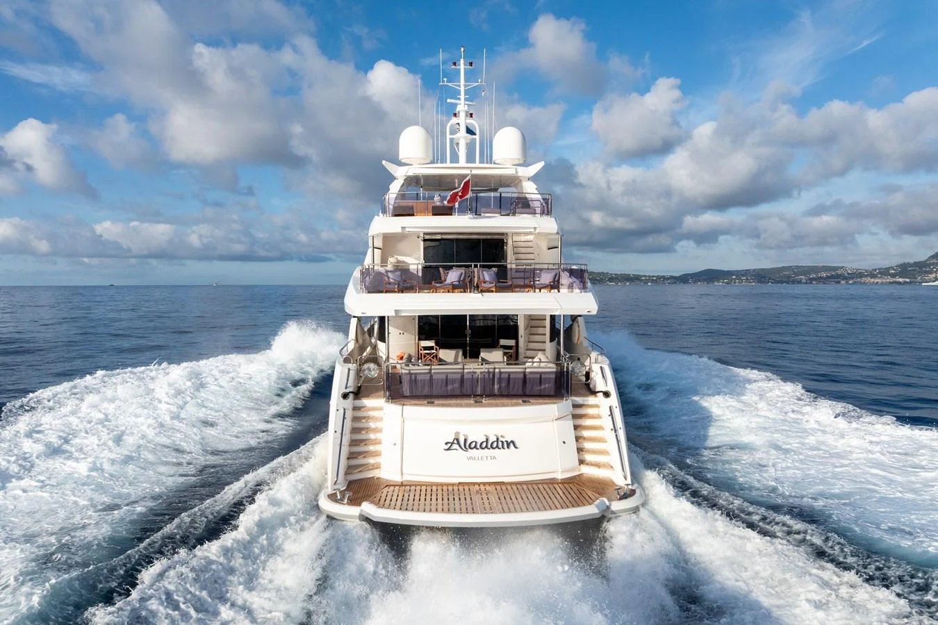The yacht is seen cruising on the open water, showcasing its impressive aft deck and multiple levels. aboard ALADDIN Yacht for Sale