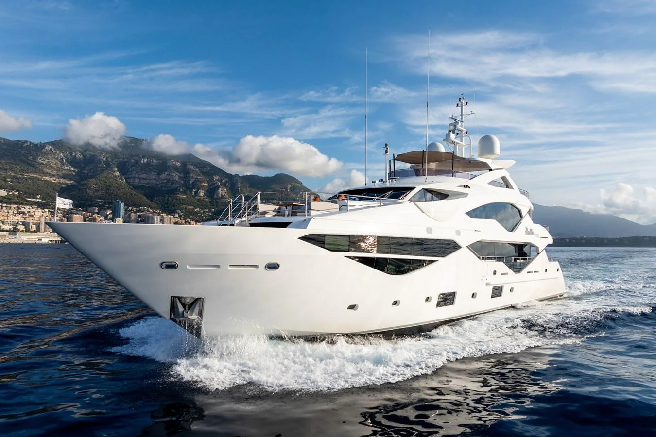 A luxurious yacht glides through the water with a scenic coastal backdrop. aboard ALADDIN Yacht for Sale
