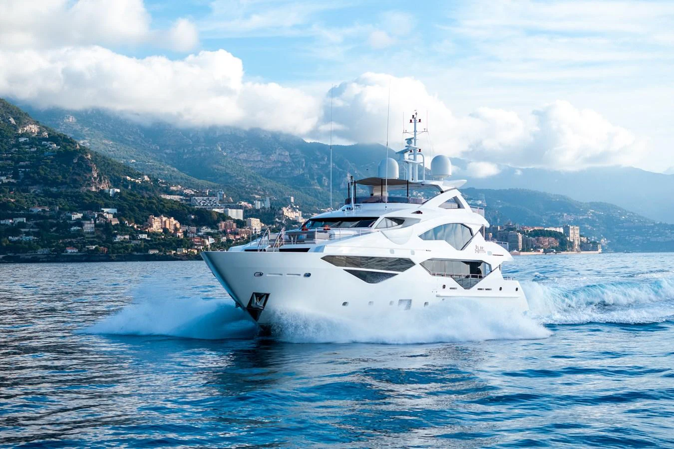 A luxurious yacht cruises through the water with a scenic coastal backdrop. aboard ALADDIN Yacht for Sale