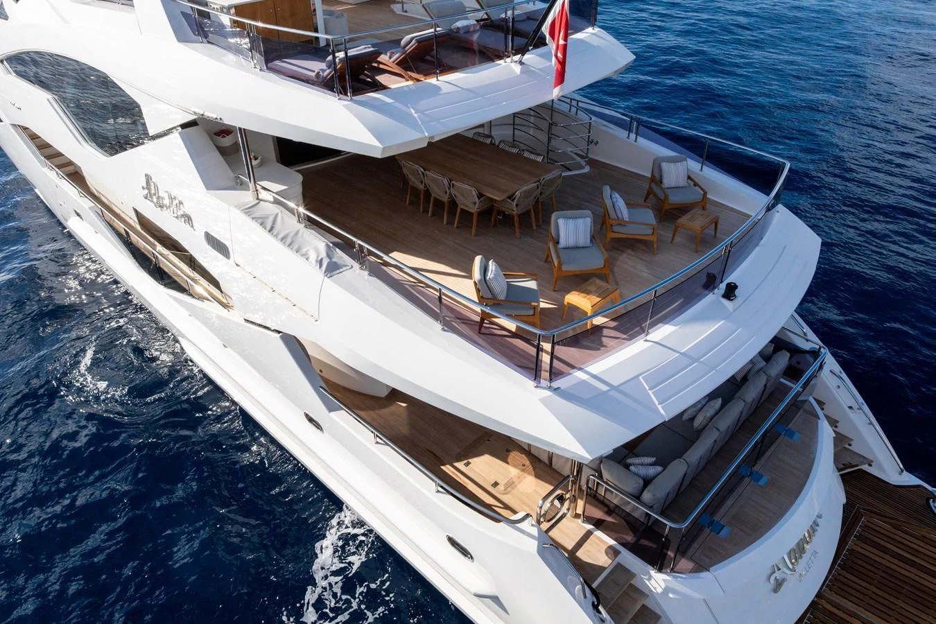 The yacht's aft deck offers a spacious and inviting area for relaxation and dining, with elegant seating arrangements and a dining table. aboard ALADDIN Yacht for Sale