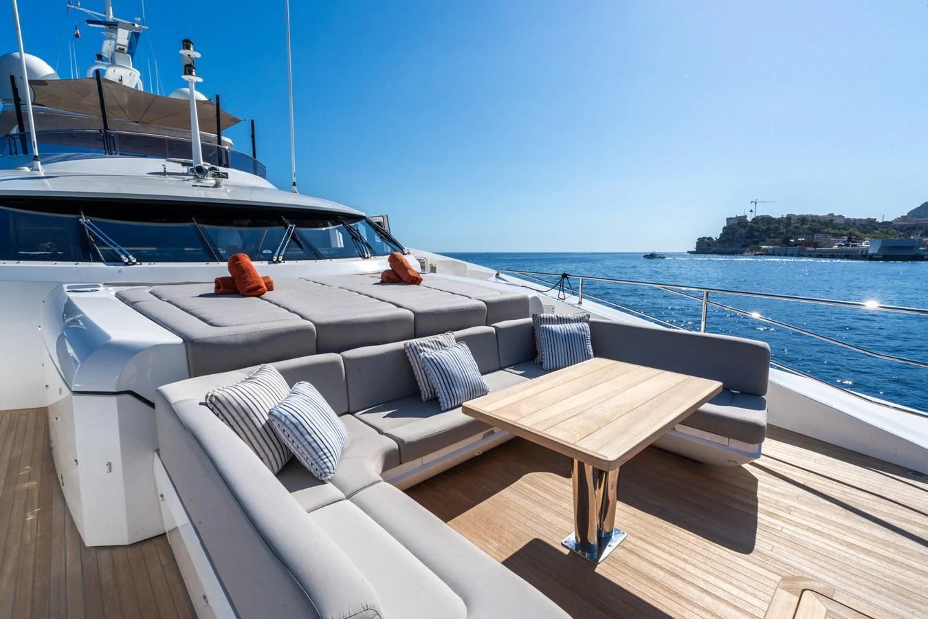 The foredeck features a spacious lounging area with plush seating and a wooden table, perfect for relaxation under the sun. aboard ALADDIN Yacht for Sale