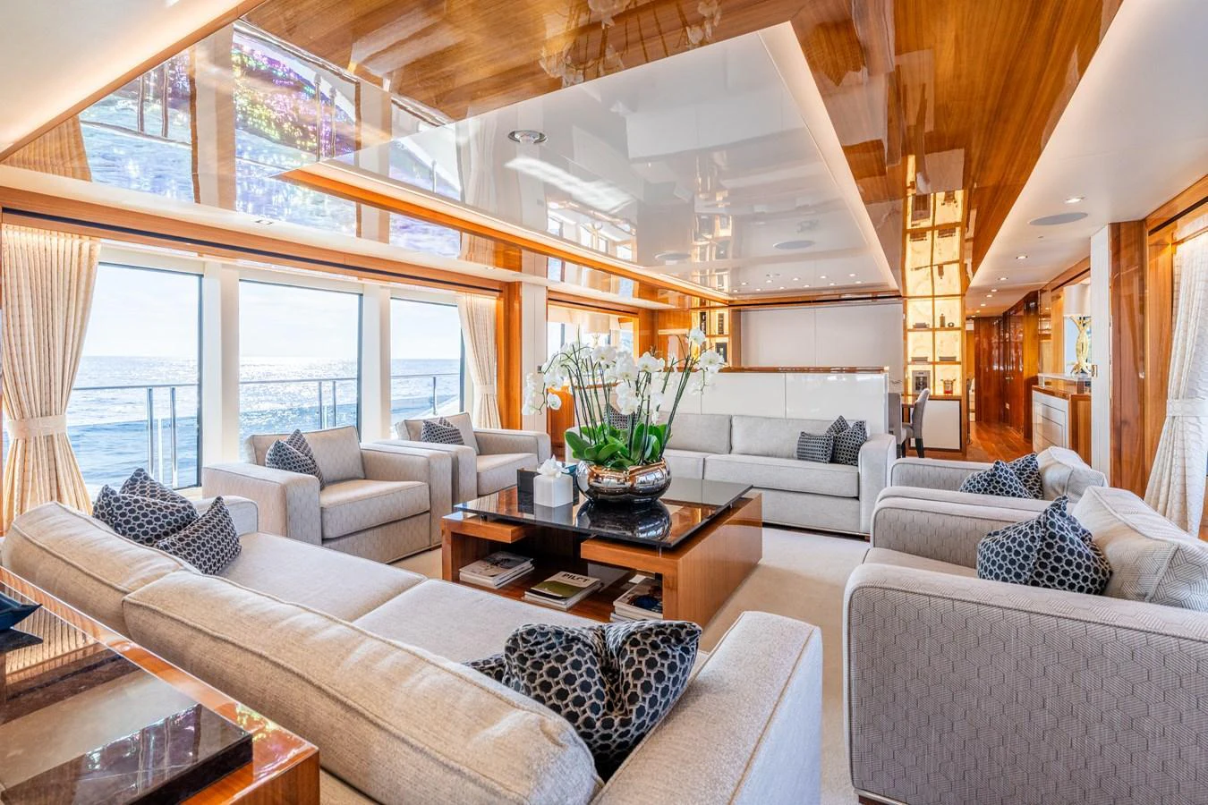 The salon features luxurious seating with ample natural light and elegant decor. aboard ALADDIN Yacht for Sale