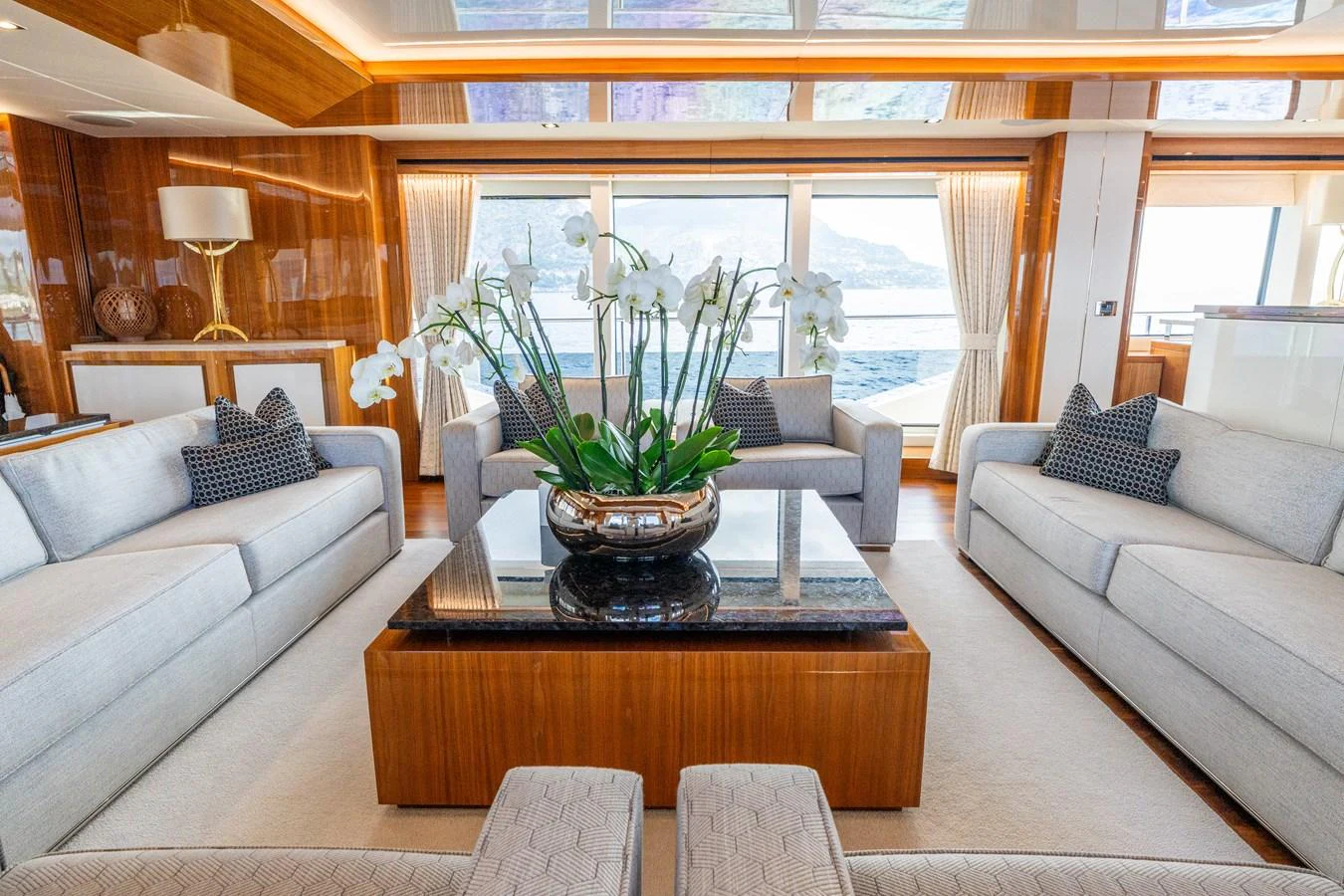 The salon features elegant seating with a central floral arrangement, offering a luxurious and inviting atmosphere. aboard ALADDIN Yacht for Sale