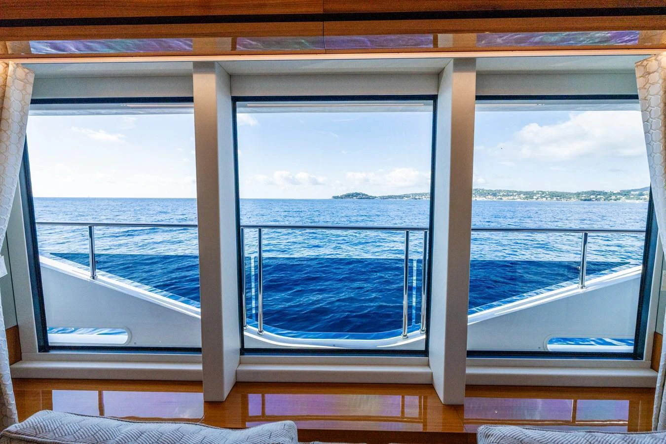 The image captures a serene view of the ocean through large windows from the interior of the yacht. aboard ALADDIN Yacht for Sale