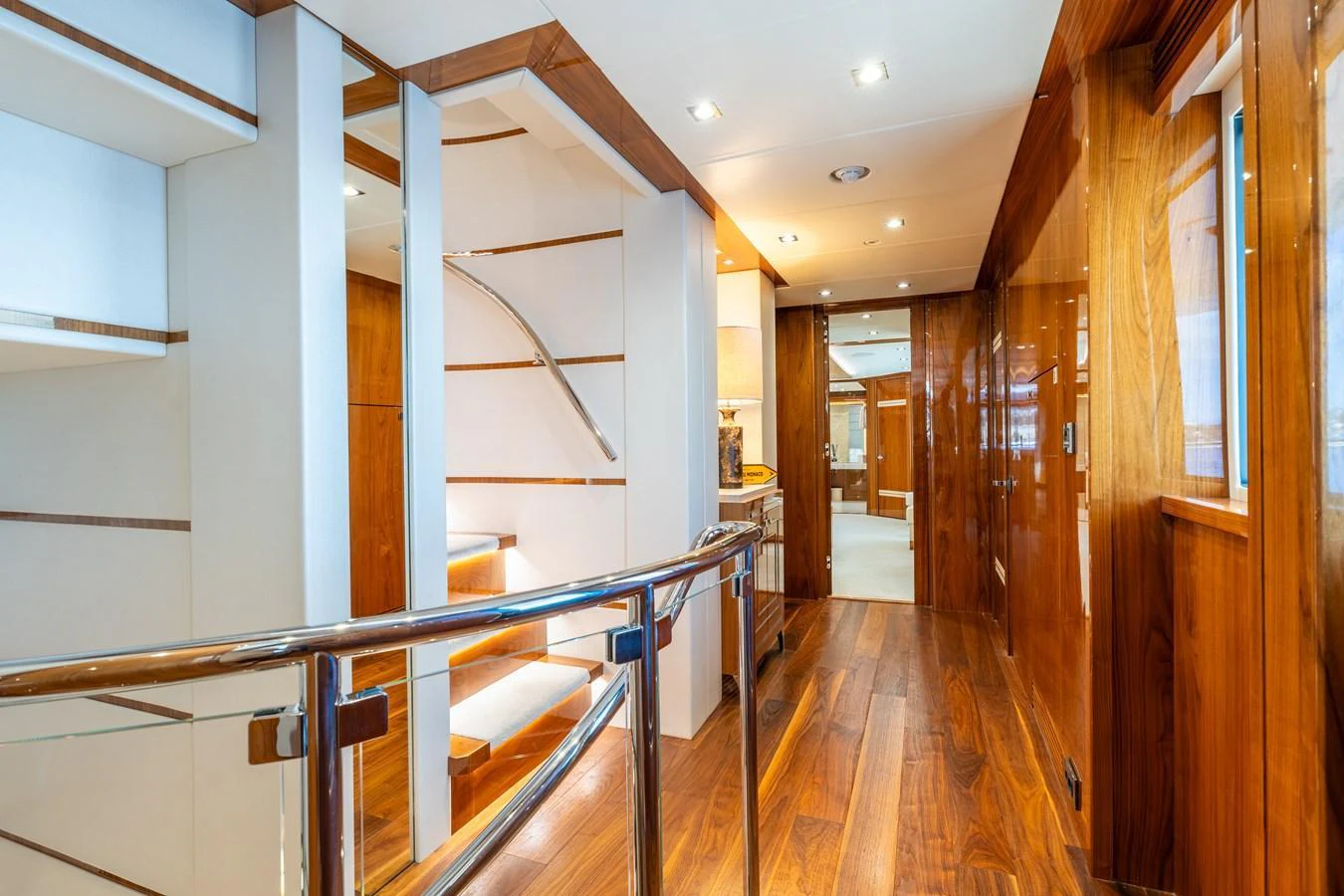 The yacht's interior features a sleek hallway with polished wood accents and modern lighting. aboard ALADDIN Yacht for Sale