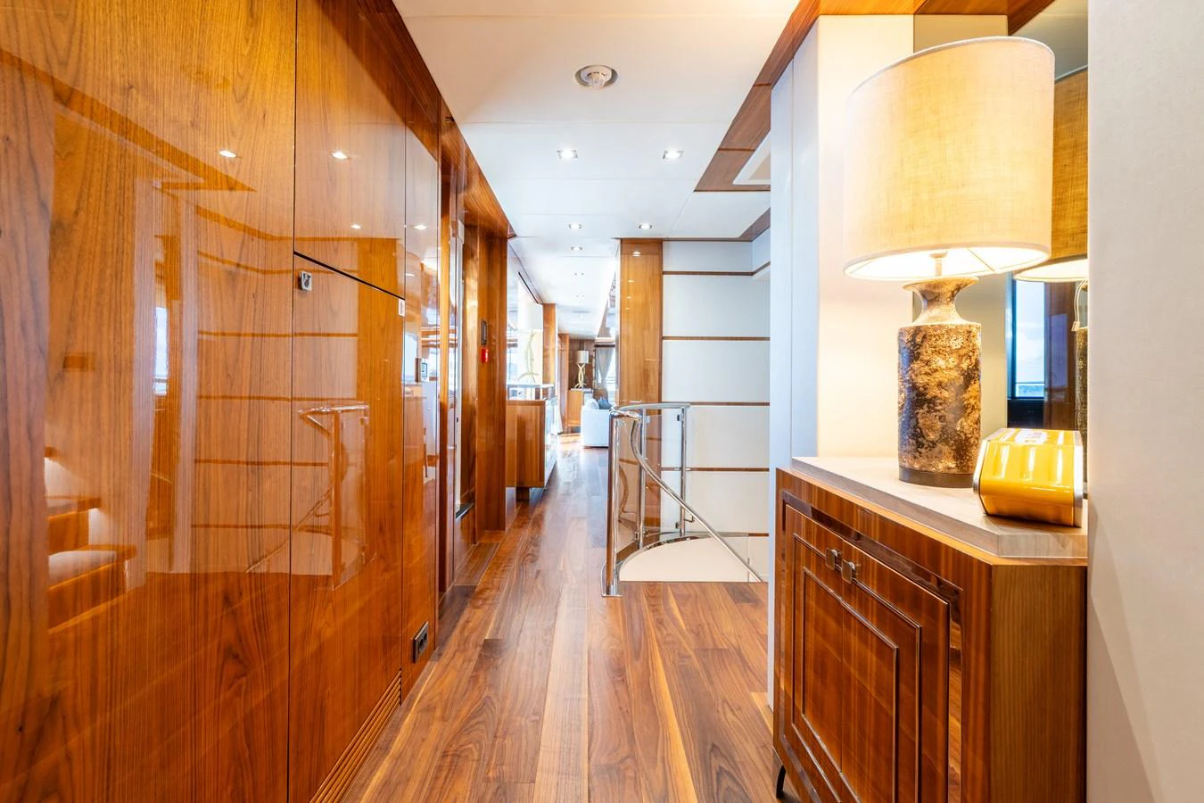 The yacht's interior hallway features elegant wood paneling and modern lighting, leading to various luxurious spaces. aboard ALADDIN Yacht for Sale