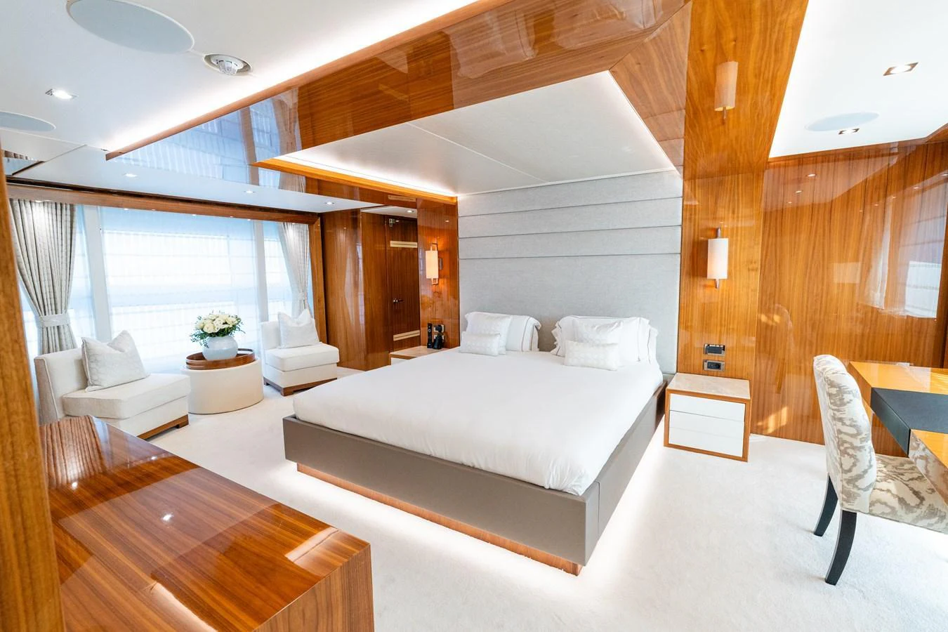 The master stateroom features luxurious wood paneling, a large bed, and ample seating. aboard ALADDIN Yacht for Sale